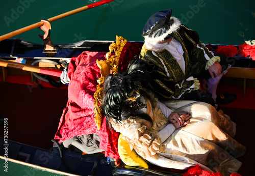 Venice, VE, Italy - February 13, 2024: married couple with historical costumes on the gondola during the carnival