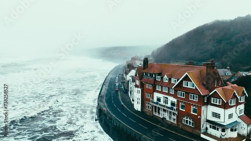 Stormy winter scene. Rough seas of the English coast with mist and fog. Aerial footage of the sleepy coastal town of Sandsend beach on the coast of north Yorkshire in England photo