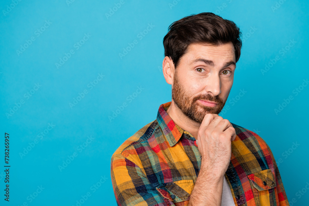 Photo of smart man with beard dressed checkered shirt keep arm on chin near proposition empty space isolated on blue color background Photo of smart man with beard dressed checkered shirt keep arm on chin near proposition empty space isolated on blue color background