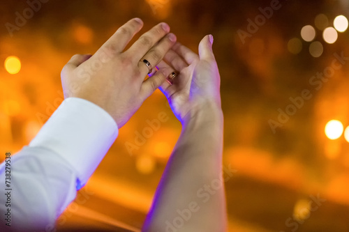 Hands of young couple are holding hands on the background of the night city