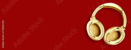 Big modern golden headphones isolated on red background. Minimal concept. Copy space for the text