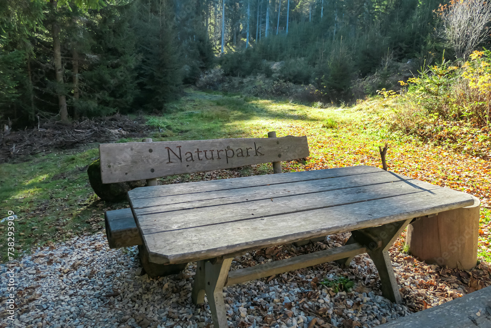 Wooden bench in idyllic forest in Grebenzen, Gurktal Alps, Styria, Austria. Engraving saying: Nature Park. Calm serene atmosphere in Austrian Alps in autumn. Enjoying a break. Escapism. Seek silence Wooden bench in idyllic forest in Grebenzen, Gurktal Alps, Styria, Austria. Engraving saying: Nature Park. Calm serene atmosphere in Austrian Alps in autumn. Enjoying a break. Escapism. Seek silence