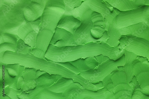 A background texture made out of green play clay. Close up. photo