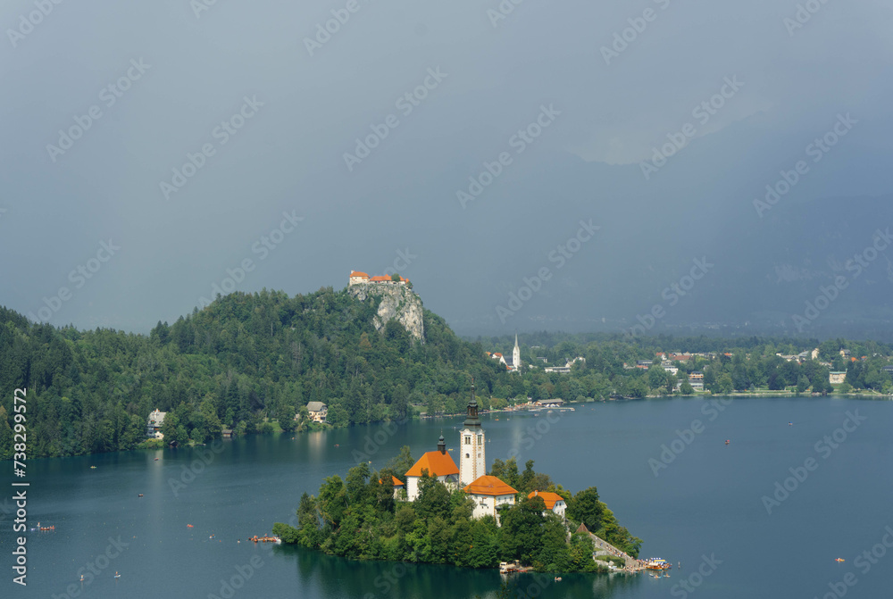 tiny island with church tower and nature in the middle of gorgeous clear water blue lake