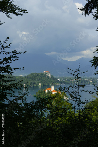 tiny island with church tower and nature in the middle of gorgeous clear water blue lake photo