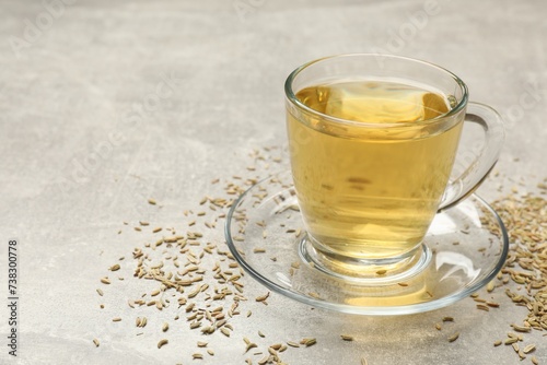 Fotografía Aromatic fennel tea in cup and seeds on light grey table, closeup