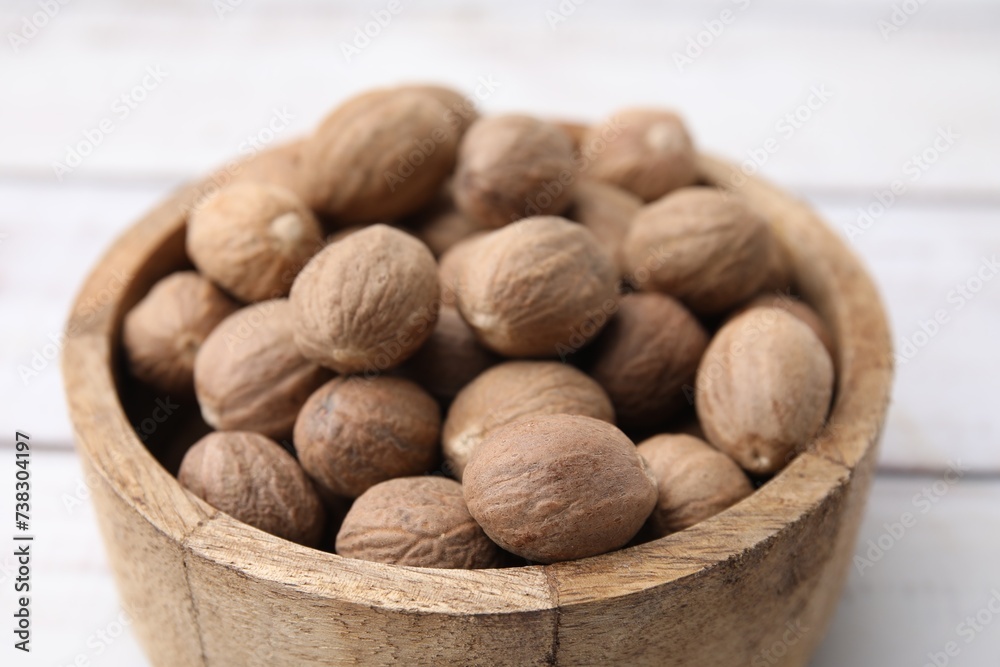 Whole nutmegs in bowl on light table, closeup Whole nutmegs in bowl on light table, closeup