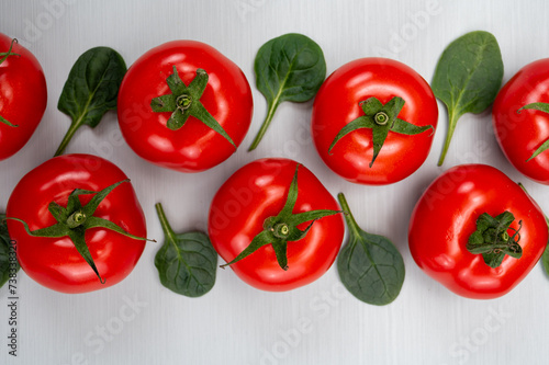 Food ornament  Red ripe tasty Dutch tomatoes and spinach leaves  vegetables background top view close up copy space