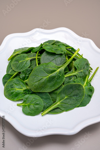 Fresh green baby Spinach leaves  diet and health concept  weight loss  spinach on ceramic plate  copy space