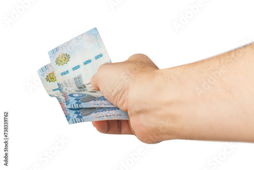 Hand-holding Saudi banknotes isolated on a white background.