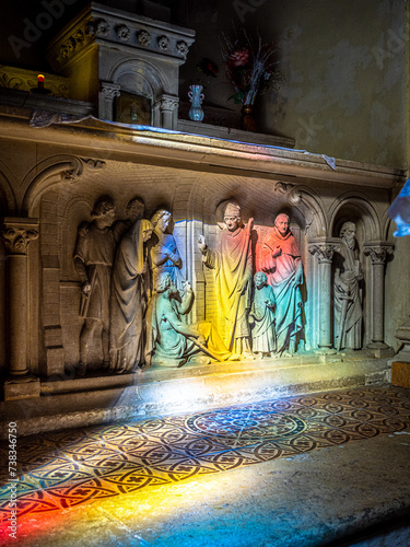 Stained light blessing a holy scultpure in a church photo