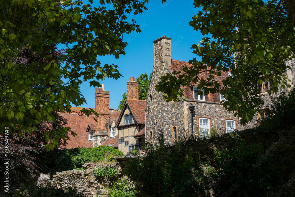 Lush treetops and ruins of stone walls frame the view of old village houses Lush treetops and ruins of stone walls frame the view of old village houses