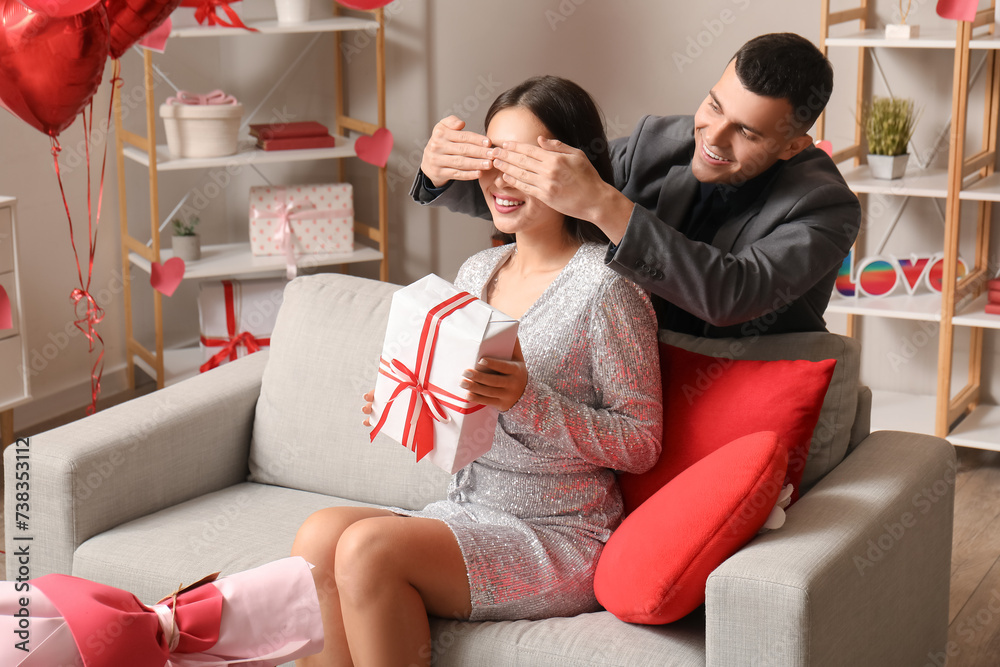Obraz premium Young man greeting his beloved girlfriend with Valentine's day at home