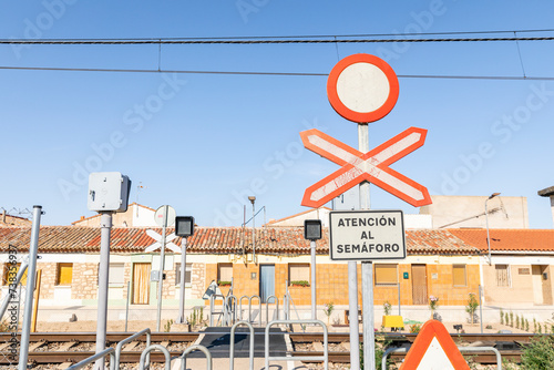 Road sign closed to vehicle traffic and unguarded level crossing sign in front of a railway crossing photo