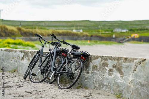 Two electric bikes parked on Inishmore, the largest of the Aran Islands in Galway Bay. Renting a bicycle is one of the most popular way to get around Inis Mor, Ireland. photo