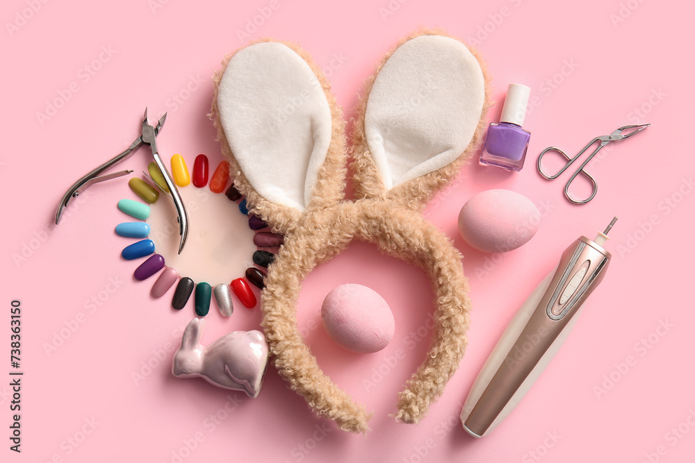 Bunny ears with Easter eggs, press-on nails and manicure tools on pink background Bunny ears with Easter eggs, press-on nails and manicure tools on pink background