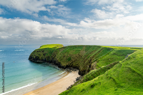 Sheep grazing near Silver Strand, a sandy beach in a sheltered, horseshoe-shaped bay, situated at Malin Beg, near Glencolmcille, in south-west County Donegal, Ireland photo