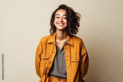 Portrait of a beautiful young woman laughing against a beige background © Igor