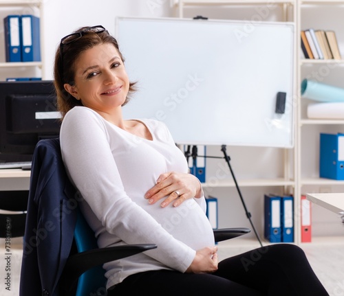 Old pregnant woman working in the office