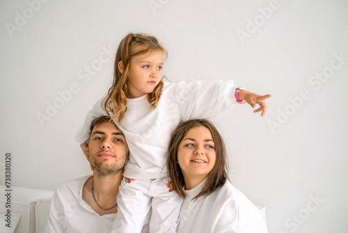 A restless girl points her finger towards sitting on her father's shoulder