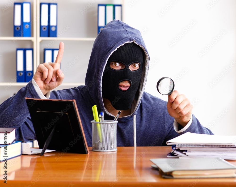 Male thief in balaclava in the office Male thief in balaclava in the office