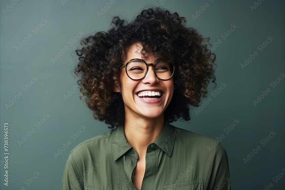 Portrait of a beautiful young african american woman laughing and wearing glasses