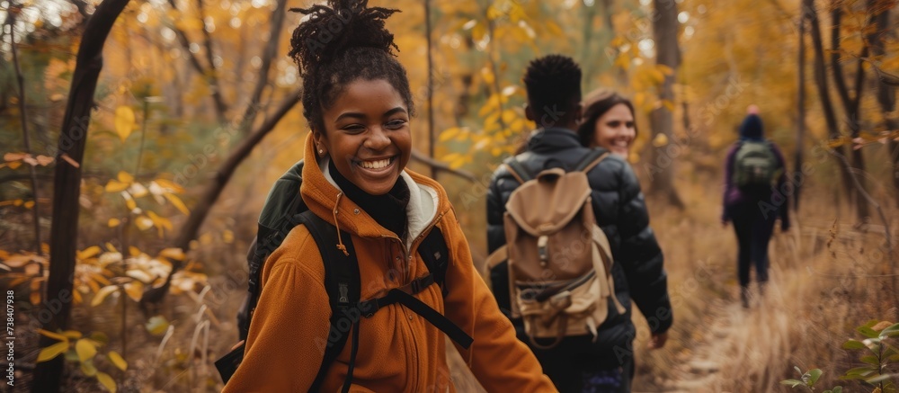 Smiling multiethnic teens holding hands while hiking in fall woods. Smiling multiethnic teens holding hands while hiking in fall woods.