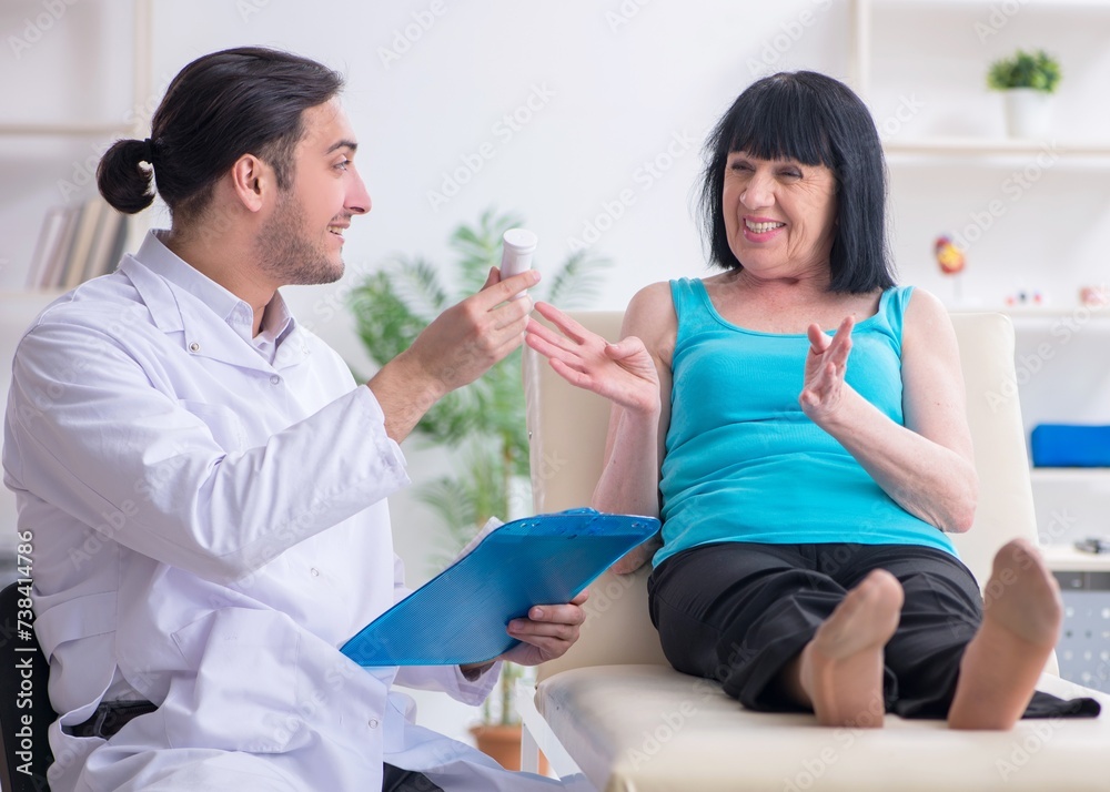 Young male doctor examining old female patient Young male doctor examining old female patient