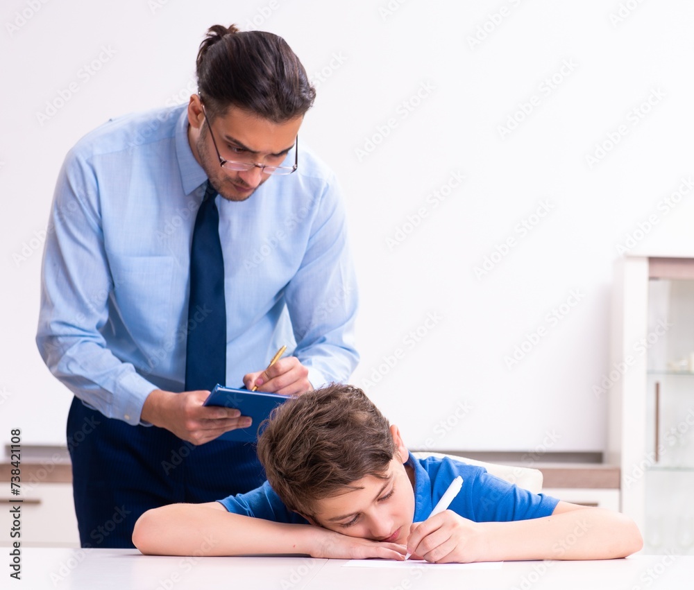 Busy father helping his son to prepare for exam Busy father helping his son to prepare for exam