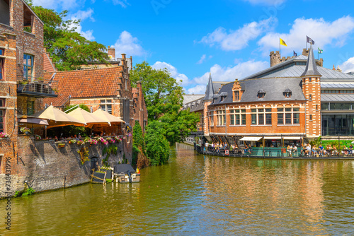 Picturesque historic buildings with outdoor patios and cafes along the scenic River Leie in the historic center of the medieval old town of Ghent  Belgium.