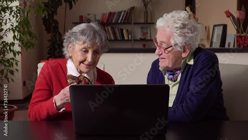 new technology: elderly couple use the computer at home photo