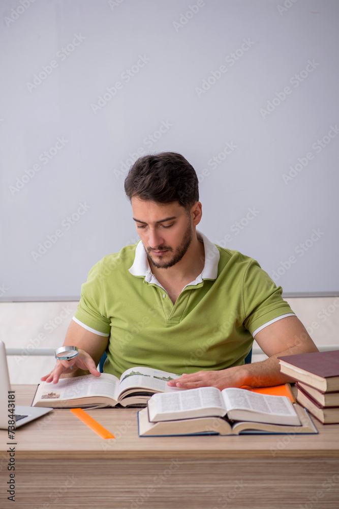 Young male student sitting in front of whiteboard Young male student sitting in front of whiteboard