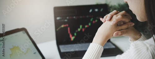 Obraz na plátně Financial investment in exchange stock concept, Young woman investor looking at laptop monitor to research the stock market on the digital marketplace platform at home