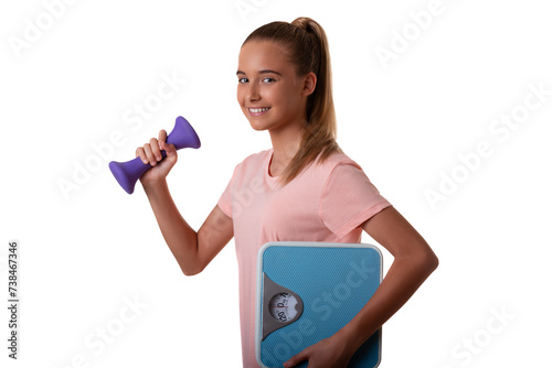 Teenager girl isolated on white background holding the dumbbells and weighing scale