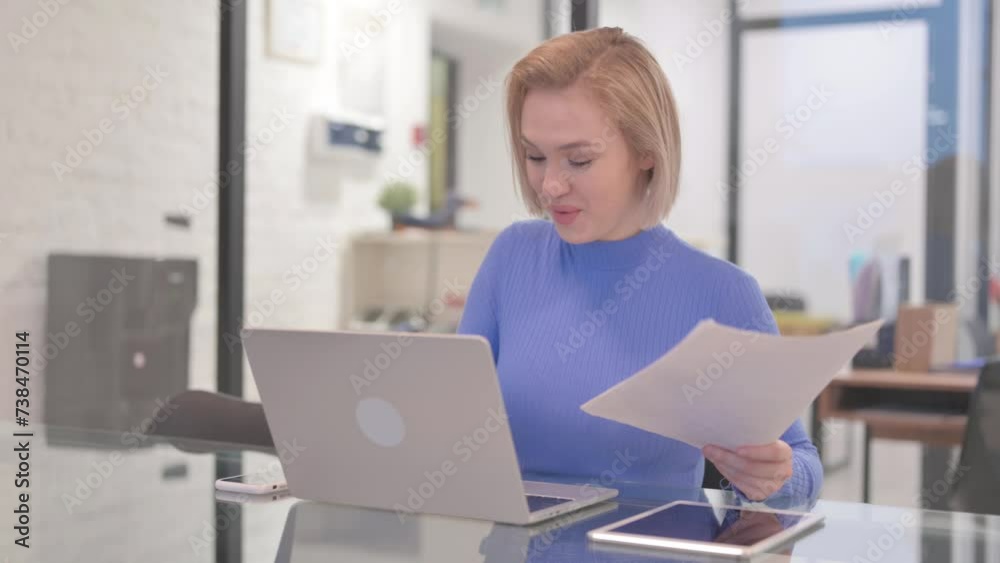 Young Woman Celebrating while Using Laptop and Documents Young Woman Celebrating while Using Laptop and Documents