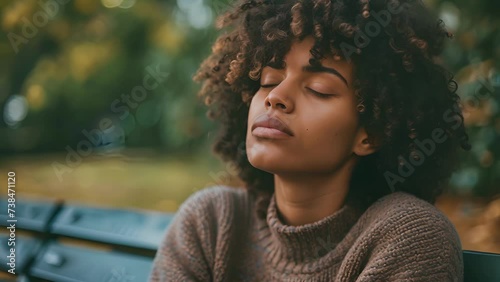 A portrait of a person sitting alone on a bench their eyes closed and expression contemplative reflecting on their own vulnerability and finding strength in it, female Sitting on a Bench With Closed photo
