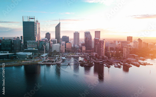 Aerial drone shot at sunrise of Perth city Western Australia, colourful sunrise sky pink, blue, orange, purple hues, views of Elizabeth Quay, swan river, city skyline, buildings, flight
