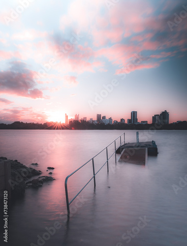 Submerged jetty long exposure photo at South Perth Foreshore, Western Australia with pink sunset. Concept of serene, beautiful calm sunset of Perth City