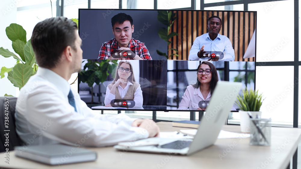 A male businessman is talking to colleagues at an online meeting A male businessman is talking to colleagues at an online meeting
