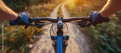 Cyclist riding a mountain bike fast in nature during summer for exercise and thrill.