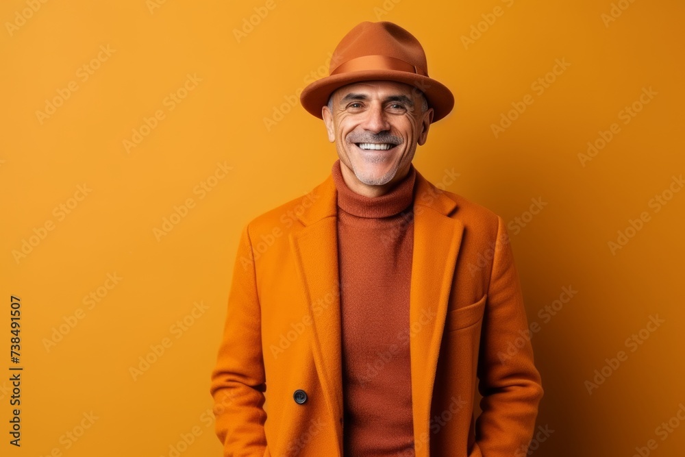 happy senior man in orange coat and hat looking at camera isolated on orange happy senior man in orange coat and hat looking at camera isolated on orange