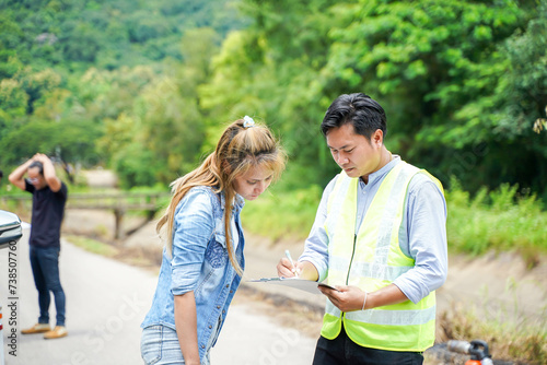 The insurance agent writing the details on the claim report form after the accident. Traffic accident insurance concept.