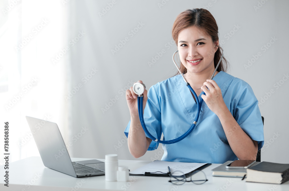 Asian female doctor working on laptop, filling out paperwork, patient medical history, reviewing documents at her workplace medical and health concept Asian female doctor working on laptop, filling out paperwork, patient medical history, reviewing documents at her workplace medical and health concept