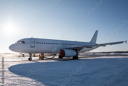 White passenger jetliner on the airport apron at winter