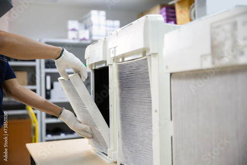 Technician holding dirty and dust air purifier filter and open cover to fix removing and change new of pm2.5 air pollution clean protect or heat maintenance air conditioner service repair. photo