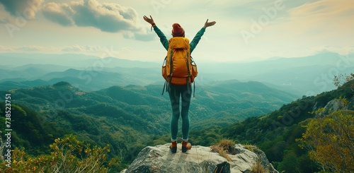 Traveler on top of a mountain with arms raised. The concept of freedom and travel.