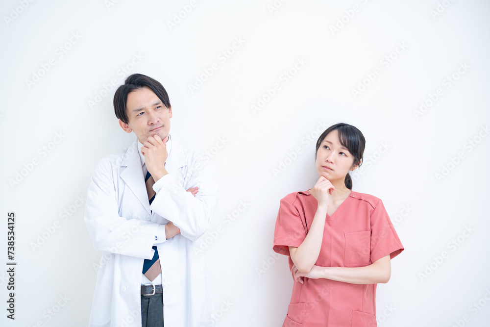 考える白衣を着た男性とスクラブを着た女性のポートレート