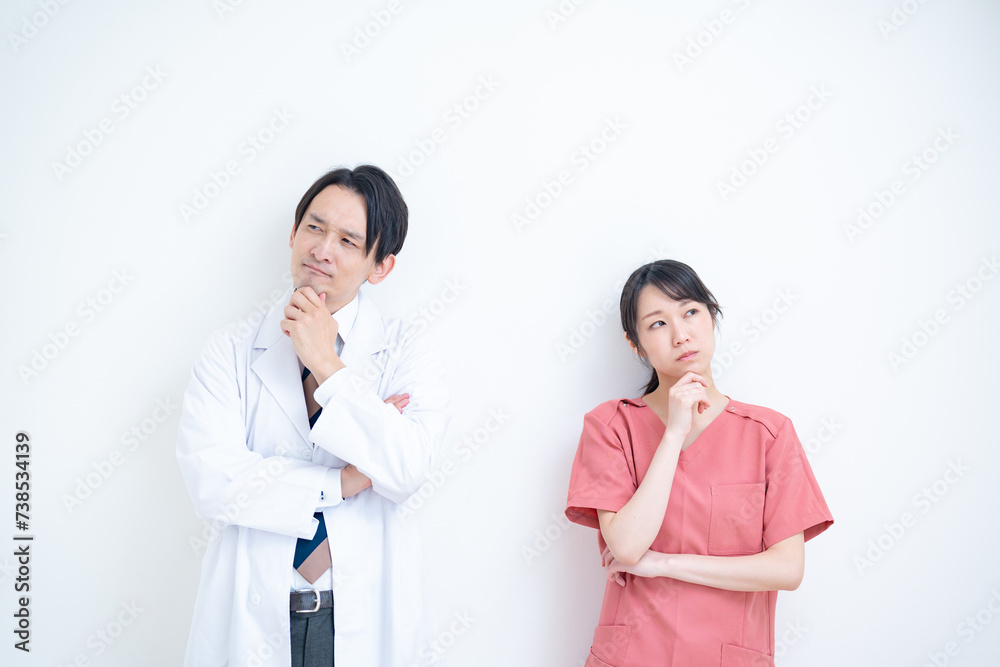 考える白衣を着た男性とスクラブを着た女性のポートレート