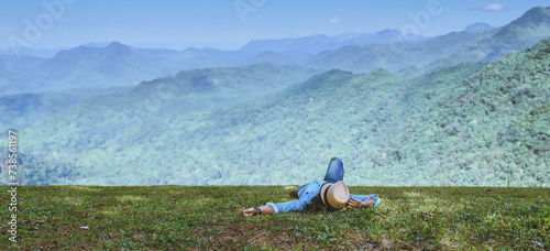 Asian man travel relax in the holiday. Sleep relax on the lawn on the mountain. In Thailand photo