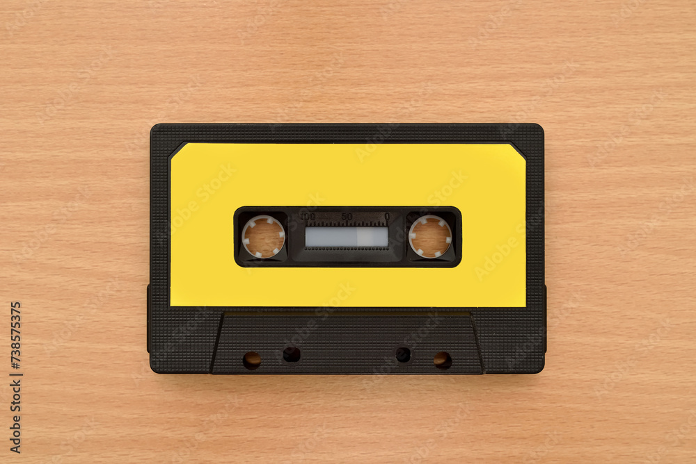 Old cassette tape on the brown wooden table. Vintage technology concept. Top view.